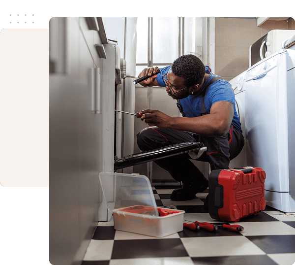 Technician repairing washing machine in laundry room