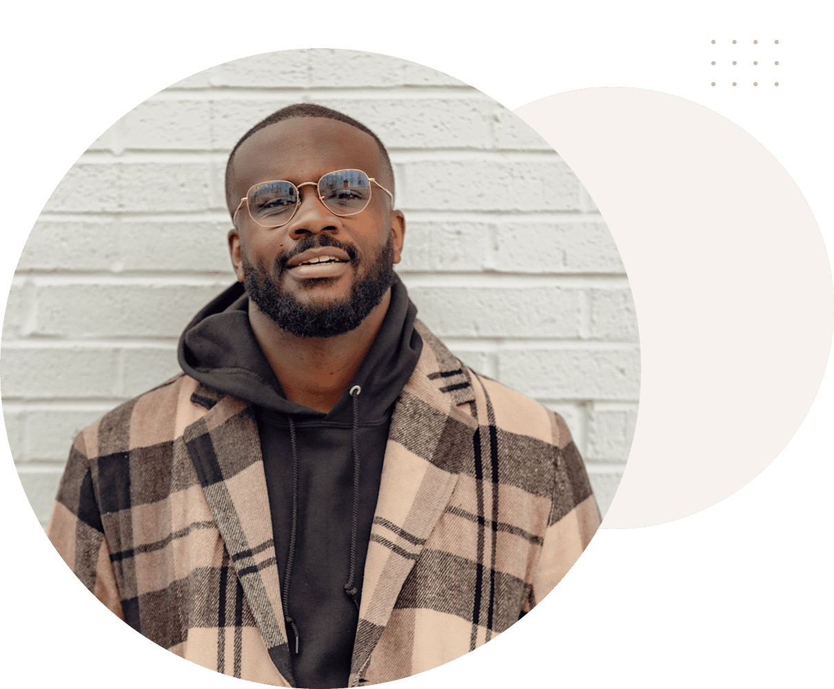 Smiling person wearing glasses and plaid coat
