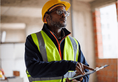 Construction worker in hard hat holding clipboard