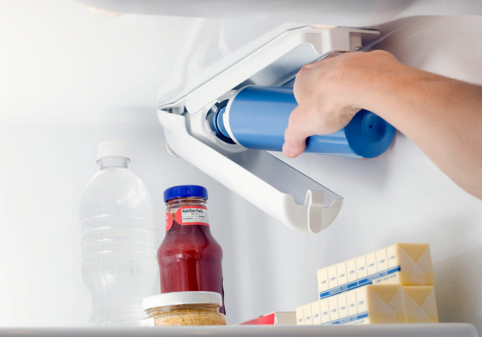 Hand replacing refrigerator water filter cartridge